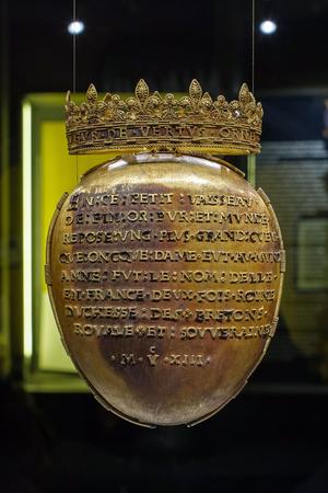 A picture shows the solid gold casket which contained the heart of the French queen Anne of Brittany, exposed by the castle of Blois, central France, as part of the commemoration of the 500th anniversary of her death, on March 21, 2014. The casket is a 500g heart-shaped box, consisting of two valves of gold with a guilloche plate held by a cord of gold. A golden crown composed of a mix of lily flowers and shamrocks is set on top of the casket. The inscription, in old French, reads : "In small vessel / pure fine gold and world / lies a bigger heart / that oncques (= never) lady had the world / Anne was the name of her / in France twice Queen / Duchess of Brittany / Royal and sovereign / 1513. " AFP PHOTO / GUILLAUME SOUVANT / AFP PHOTO / GUILLAUME SOUVANT